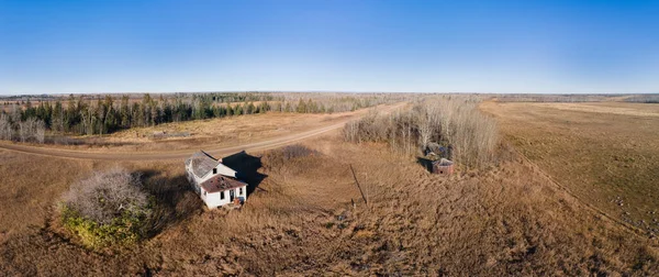 空中是一座废弃的白色小农舍 周围是干草和几座孤零零的小茅屋 — 图库照片