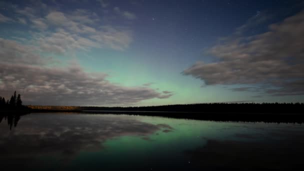 非常に穏やかな湖の上を移動する雲と星空の夜のビデオを失いました 緑のオーロラ 赤いパッチが空を照らし 静かな水に反射する — ストック動画