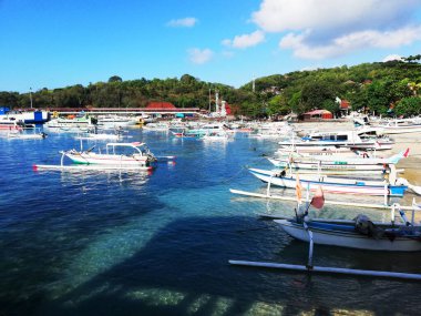 Bali,Indonesia - September 4 2022 : Padang Bai harbour in Karangasem regency of Bali.Looks the traditional wooden boat of local people are docking on the harbour during a sunny day.