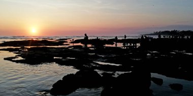 Bali, Endonezya - 3 Ekim 2023: Tabanan 'daki Tanah Lot tapınağı, gün batımında birçok ziyaretçiyle