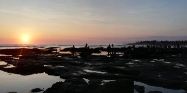 Bali, Endonezya - 3 Ekim 2023: Tabanan 'daki Tanah Lot tapınağı, gün batımında birçok ziyaretçiyle