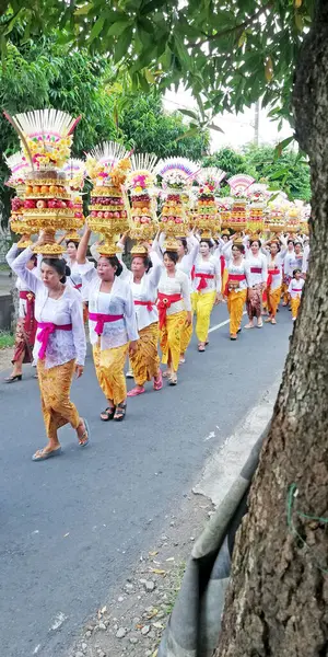 Stock image Bali,Indonesia - March, 21st 2024 : Bali temple festival procession on the street with many colorful of big offerings