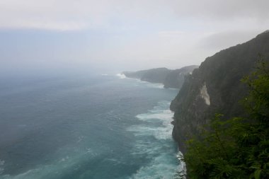 Kelingking Plajı, Nusa Penida adası Bali 'de, beyaz uçurum oluşumu ve gündüz vakti beyaz kum plajı