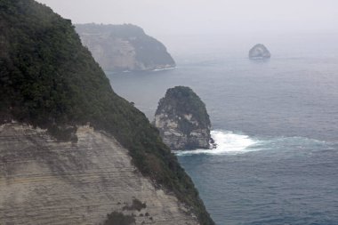 Kelingking Plajı, Nusa Penida adası Bali 'de, beyaz uçurum oluşumu ve gündüz vakti beyaz kum plajı