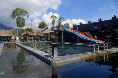 Bali,Indonesia - July 18th 2023 : Hot Spring swimming pool at Kintamani Bali, with colorful water slide clipart