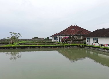 BALI, INDONEZYA-10 Mayıs 2025: Bali Endonezya 'nın Tabanan naipliğindeki Bolangan köyü. Beyaz ve mavi nefesli balık havuzlu balıkçı çiftliği binası.