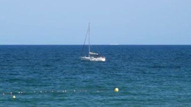 İspanya, Barcelona - 29 Mayıs 2022: Küçük beyaz yelkenli ve Güzel Açık Gök manzaralı Balear Denizi. - Evet. Yüksek kalite 4k görüntü