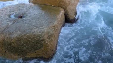 Gün batımında Balear Denizi 'ndeki Dalgakıranlara Karşı Su Sıçramaları' nın Yakın Çekimi. Barcelona, İspanya 'daki Pier On Beach' ten görüntü. Yüksek kalite 4k görüntü