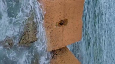 Günbatımında Balear Denizi 'ndeki Dalgakıranlara Karşı Su Sıçramalarının Dikey Görüntüsü. Barcelona, İspanya 'daki Pier On Beach' ten görüntü. Yüksek kalite 4k görüntü