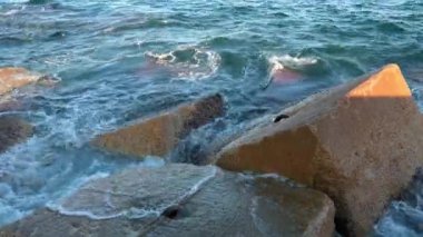 Gün batımında Balear Denizi 'ndeki Dalgakıranlara Karşı Su Sıçramaları' nın Yakın Çekimi. Barcelona, İspanya 'daki Pier On Beach' ten görüntü. Yüksek kalite 4k görüntü