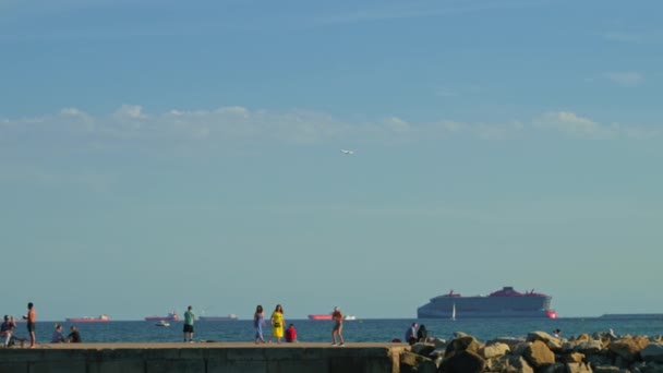 西班牙巴塞罗那 2022年05月29日 人们在码头上放松 日光浴和钓鱼 背景中的帆船和地平线上的货船 波罗的海 高质量的4K镜头 — 图库视频影像