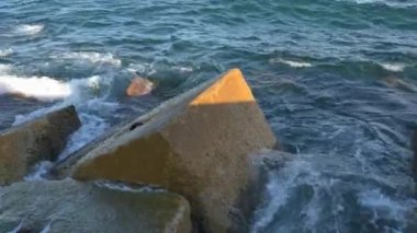 Gün batımında Balear Denizi 'ndeki Dalgakıranlara Karşı Su Sıçramaları' nın Yakın Çekimi. Barcelona, İspanya 'daki Pier On Beach' ten görüntü. Yüksek kalite 4k görüntü