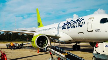 Kerkyra, Yunanistan - 09 29 2022: AirBaltic 'in Yeşil Uçağı Korfu Havaalanı manzarası. Uçak için otopark, kalkıştan önce bavullarla doludur. Yüksek kalite fotoğraf