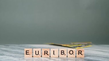 EURIBOR 'un Sabit Çekimi Gri Arkaplanda Tahta Harflerle Yazılıyor. Kadın El 200 Euro 'luk banknot fırlattı. Ekonomik kriz kavramı. Yüksek kalite 4k görüntü