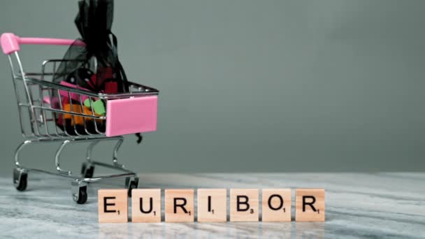 欧洲文字的静态射击是用灰色背景的木制字母书写的 在两个空购物篮后面降低购买力的概念 高质量的4K镜头 — 图库视频影像