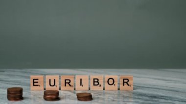 EURIBOR 'un Sabit Çekimi Gri Arkaplanda Tahta Harflerle Yazılıyor. Ön planda, Kadın Avro Cent Yığını Yığıyor. Azalan Tasarruf kavramı. Yüksek kalite 4k görüntü