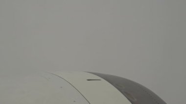 View from Boeing on On Thick Gray Clouds, Sky Is Not Visible. Turbulence in bad weather. In frame White-Grey Engine Casing With Vanes. High quality 4k footage