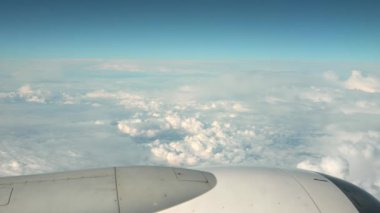 View from Plane on White Air Clouds And Clear Blue Sky. In frame White-Grey Engine Casing With Vanes. High quality 4k footage
