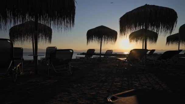 Timelapse Sunrise Silhouettes Beach Chairs Umbrellas People Walking Beach Moraitika — Videoclip de stoc