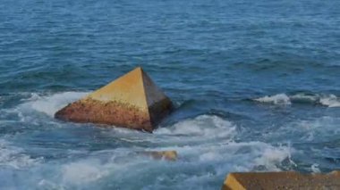 Gün batımında Balear Denizi 'ndeki Dalgakıranlara Karşı Su Sıçramaları' nın Yakın Çekimi. Barcelona, İspanya 'daki Pier On Beach' ten görüntü. Yüksek kalite 4k görüntü