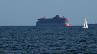 Barcelona, Spain - May 29 2022: In Foreground Is Small Sailing Ship With Vacationers, In Background Is Tank And Large Cruise Ship in Balearic Sea. High quality 4k footage