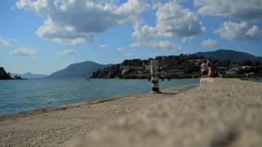 Kerkyra, Yunanistan - 09: 24 2022: Kanoni 'de Zaman Köprüsü - İnsanların ve turistlerin yürüdüğü ve güzel fotoğraflar çekmek için uçağın inmesini bekledikleri Corfu Havaalanı' nda Perama Köprüsü. Arkaplanda