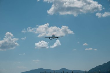 Kerkyra, Yunanistan - 09: 24 2022: Mavi gökyüzüne karşı dağların üzerinden uçan Easy jet uçağının ön görüntüsü. Yüksek kalite fotoğraf