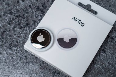 Jurmala, Letonya - 21 09 2023: eşyalarınızı takip etmek için cihaza yakın çekim - AirTag Apple. Kutuda hava etiketi var. Yüksek kalite fotoğraf