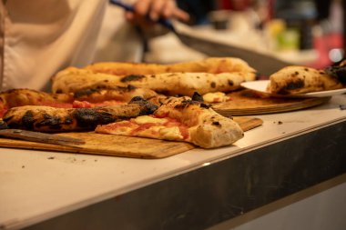 Masanın üzerinde yanık kenarlı, Napoli usulü mozzarella peynirli pizza dilimleri var. Yüksek kalite fotoğraf