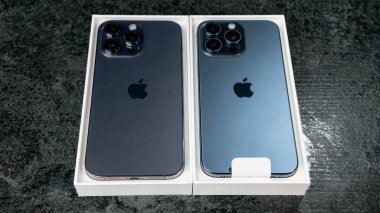 Jurmala, Letonya - 30 11 2023: Yeni iPhone 15 mavi Titanyum ve gri masada daha önceki iPhone 14 Pro Max ile birlikte açık kutu. Yüksek kalite fotoğraf