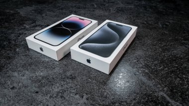 Jurmala, Letonya - 30 11 2023: Yeni iPhone 15 Mavi Titanyum ve önceki iPhone 14 Pro Max 'li kutu gri masada.