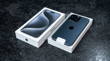 Jurmala, Letonya - 30 11 2023: Kutu ve yeni akıllı telefon iPhone iPhone 15 Pro Max in Blue Titanium rengi gri masa. Yüksek kalite fotoğraf