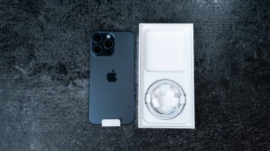 Jurmala, Letonya - 30 11 2023: gri masada mavi Titanyum renkli yeni akıllı telefon iPhone 15 Pro Max 'in kutusunu açmak. Yüksek kalite fotoğraf
