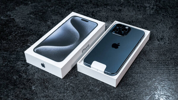 Jurmala, Latvia - 30 11 2023: Box and new smarphone apple iPhone 15 Pro Max in Blue Titanium color on grey table. High quality photo