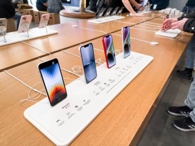 Barselona, İspanya - 13.01.2024: Barcelona 'daki resmi mağazada farklı iPhone' lara sahip bir stand. İnsanlar telefonu deniyor. Yüksek kalite fotoğraf