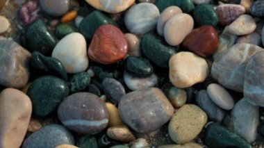 Yeşil, kırmızı ve beyaz da dahil olmak üzere çeşitli renklerde taş yığınları. Kayalar dağılıp birbirine karışarak doğal ve dünyevi bir his yaratıyor.
