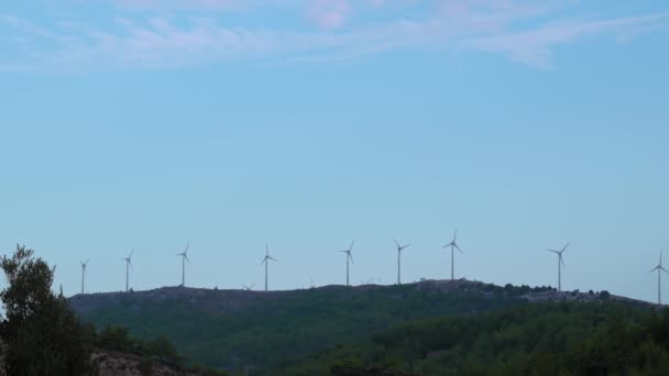 山坡上有一排风力涡轮机 天空是蓝色的 太阳是闪亮的 — 图库视频影像