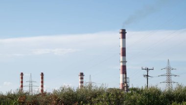 Uzakta bir sıra uzun kırmızı ve beyaz enerji santralleri görülebilir. Yüksek kalite fotoğraf