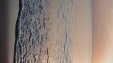 Okyanus sakin ve gökyüzü güzel turuncu bir renktir. Dalgalar küçük ve su berrak.