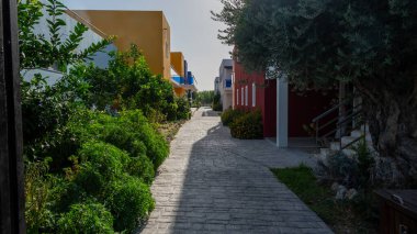 İki bina arasında dar bir geçit var ve güzel bir şekilde çeşitli ağaçlar ve gür çalılarla çevrili.