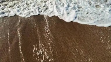 Güneş batarken kumlu bir plajda süzülen okyanus dalgalarının rahatlatıcı sesini hissedin. Kıyıda güzel altın bir ışık yayıyor. Bu huzurlu anın tadını çıkar..