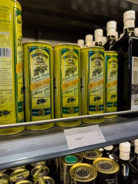 Rodos, Yunanistan - 01.10.2024: Canlı ambalaj paketlerindeki bir dizi ekstra bakire zeytinyağı, bir marketin raflarında çeşitli marka ve fiyatların sergilendiği,.