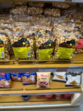 Rodos, Yunanistan - 01.10.2024: İyi organize edilmiş bir rafta çeşitli çerezlerin yanı sıra limon aromalı birden fazla paket şam fıstığı sergileniyor. Parlak ambalaj mağazada müşterilerin dikkatini çekiyor.