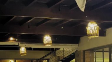 Yumuşak parlayan ışıklar çağdaş bir kafenin davetkar atmosferini arttırır ve akşam müşterileri için sıcak bir ortam yaratır..