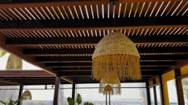 Güzel asılı ışıklar ve yemyeşil yeşilliklerle dolu sakin bir açık hava yemeğinin tadını çıkarın. Denizin rahatlatıcı manzarası rahatlamak için mükemmel bir ortam yaratır..