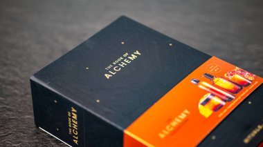 Jurmala, Letonya 14.12.2024: Vücut bakımı kozmetik... Simya Kitabı. Simya üzerine bir kitabın ambalaj tasarımı Karanlık Arkaplan üzerinde canlı elementleri ve zarif tipografiyi gösteriyor