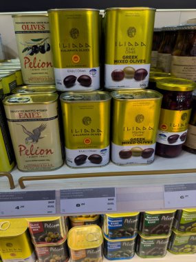 Rodos, Yunanistan - 01.10.2024: Kalamata zeytinleri ve Yunan karışık zeytinlerinin belirgin etiketli ve fiyatlandırılmış olduğu bir market rafında çok sayıda zeytin konservesi düzgünce düzenleniyor.