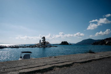 Uzakta küçük bir adası olan güzel mavi bir okyanus. Su sakin ve gökyüzü berrak.