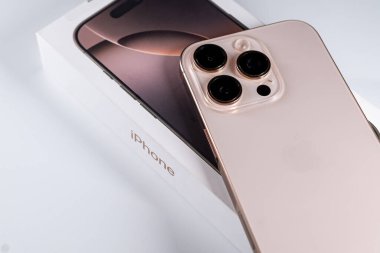 Jurmala, Letonya - 31.05.2025: Apple Iphone 16 Pro Desert Titanium. Zarif ambalajının yanına yerleştirilmiş. Tasarım sofistike estetiği vurguluyor. Yüksek kalite fotoğraf