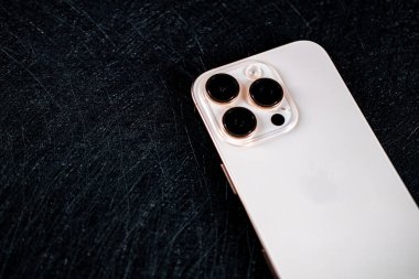 Jurmala, Letonya - 31.05.2025: Siyah arka plan üzerine yakın plan Apple Iphone 16 Pro Desert Titanium.
